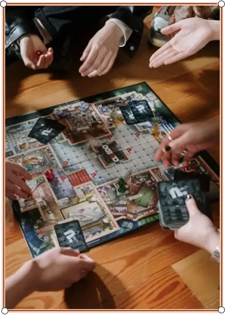 Een groep Een groep mensen zit bij elkaar op een houten vloer en speelt een bordspel met kaarten en een kleurrijk speelbord. Ze zijn druk bezig met hun handen, wat zorgt voor een levendige en interactieve sfeer.mensen zit bij elkaar op een houten vloer en speelt een bordspel met kaarten en een kleurrijk speelbord. Ze zijn druk bezig met hun handen, wat zorgt voor een levendige en interactieve sfeer.